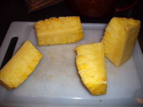 Cut the pineapple into quarters.