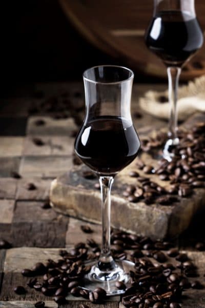Two flutes with coffee liqueur surrounded by scattered coffee beans