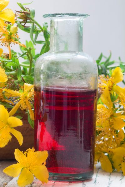 A bottle of ruby red St. Johns Wort Tincture by St. Johns Wort yellow flowers