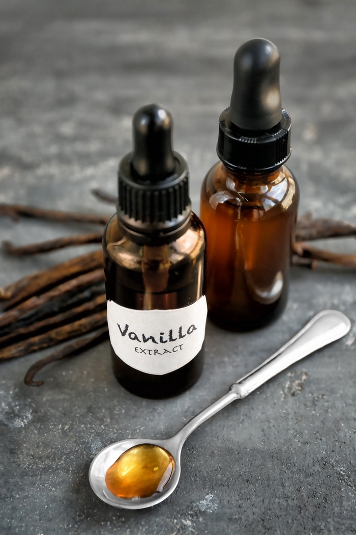 vanilla extract in bottles by fresh vanilla beans