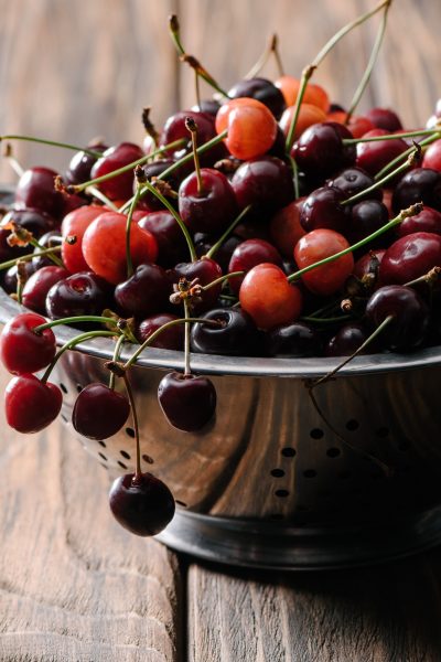 Ripe cherries spilling out of a colander