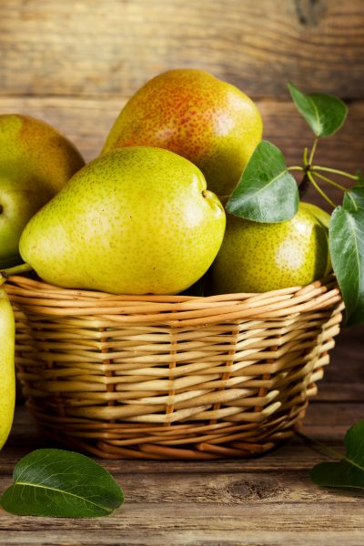 Fresh pears stacked in a wicker bowl