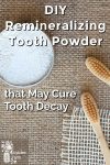 Tooth powder in a container by a couple bamboo toothbrushes