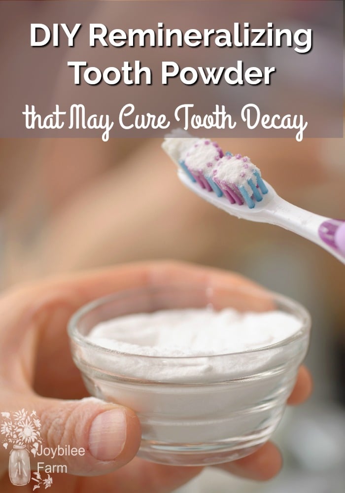 Hand holding tooth powder and tooth brush