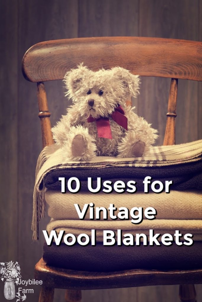 A teddy bear sitting on a pile of wool blankets