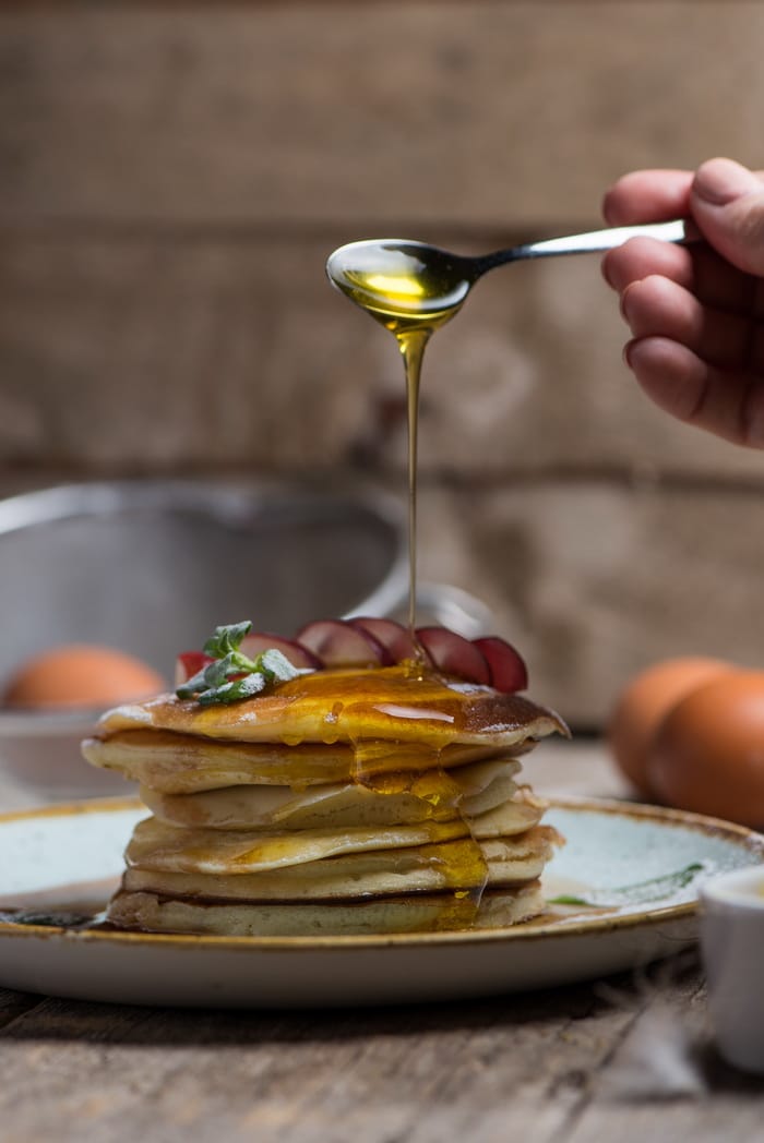 A stack of pancakes drizzled with birch syrup