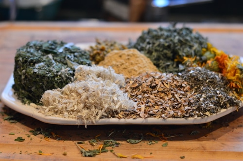 dried herbs on white plate sitting on a table