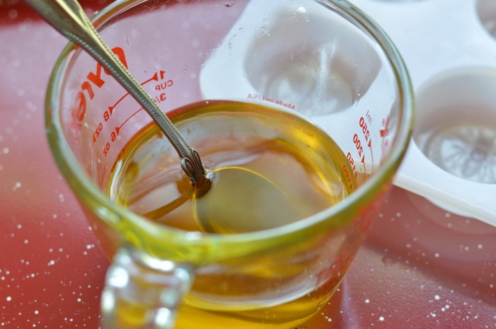 Melted beeswax in a glass measuring cup