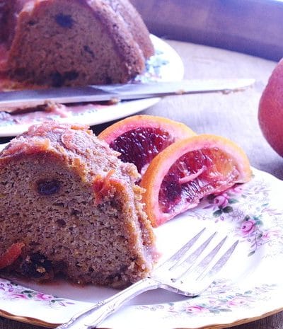 cake on white dish with blood orange garnish