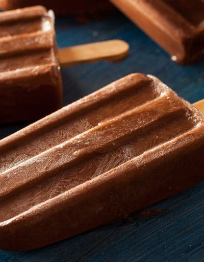 Homemade fudgsicles on a blue cutting board