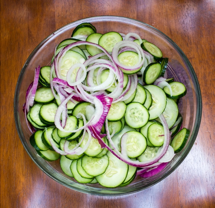 cucumbers and onions sliced into chips for pickle making