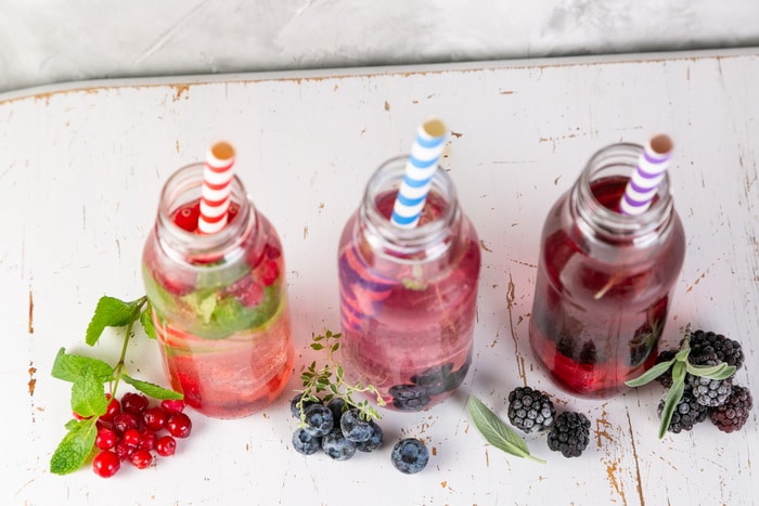 drinking vinegar in glass bottles with colorful straws