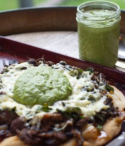 asparagus pesto in a jar, and on pizza in the foreground.