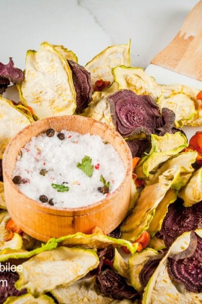 various veggie chips on a platter with dip