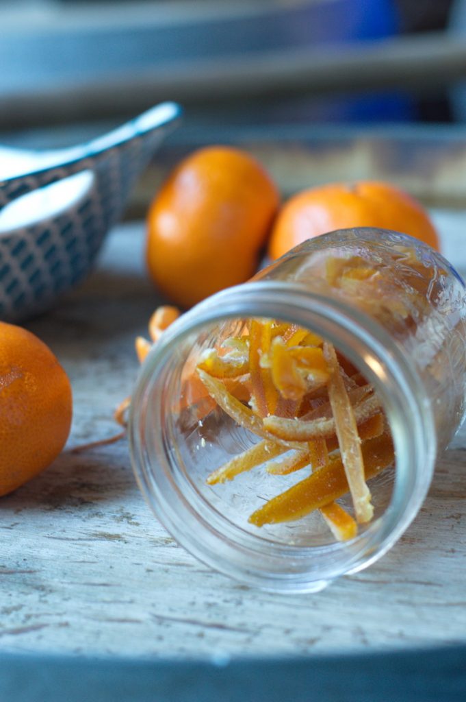 Glass jar on its side with candied orange peel and samutra oranges