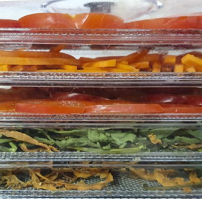 Blanching vegetables and placing them on dehydrator racks