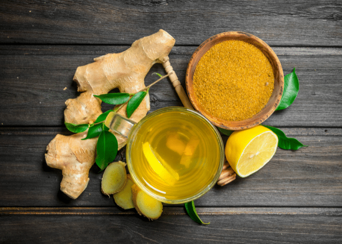 lemon, ginger, and turmeric tea ingredients on a dark wooden background