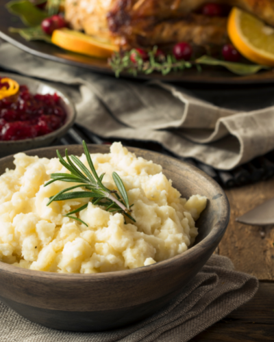 holiday layout of mashed potatoes from scratch, cranberry dressing, and background turkey