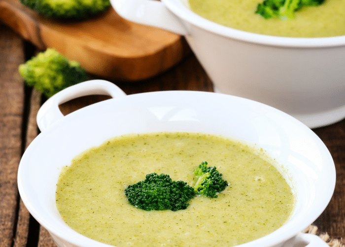 cream of broccoli soup in a white bowl with intact broccoli on top of the cream soup. Make your own dried cream soup base to have cream of broccoli soup at your fingertips.